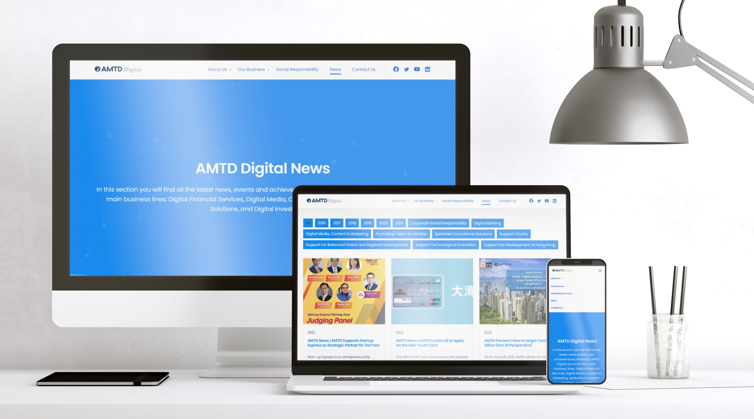 AMTD International website shown in various responsive devices with work desk background