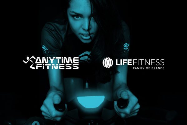 Anytime Fitness and Life Fitness white logo with dark background showing a woman working out looking at the camera