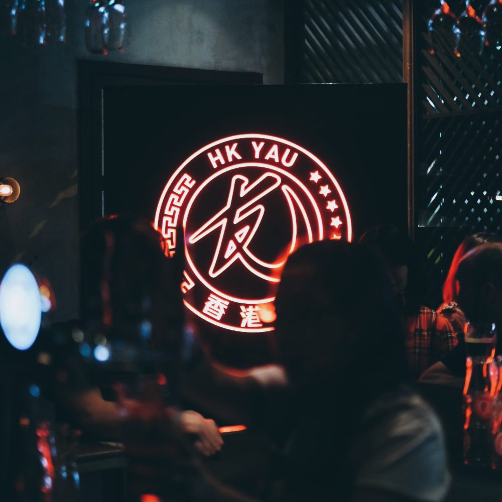 HK YAU neon logo in a bar