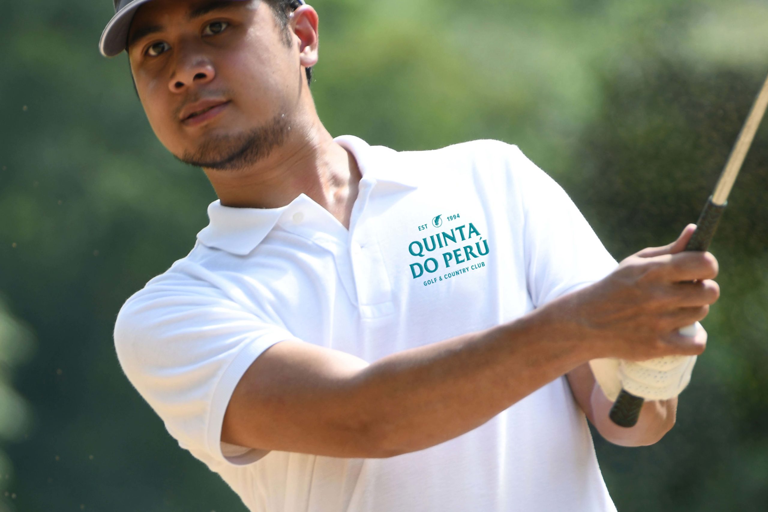 QDP Quinta Do Peru Golf & Country Club turquoise logo printed on golf shirt worn by a golfer