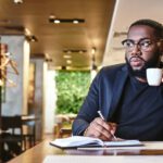 man sitting in coffee shop organising budget for branding startup spend